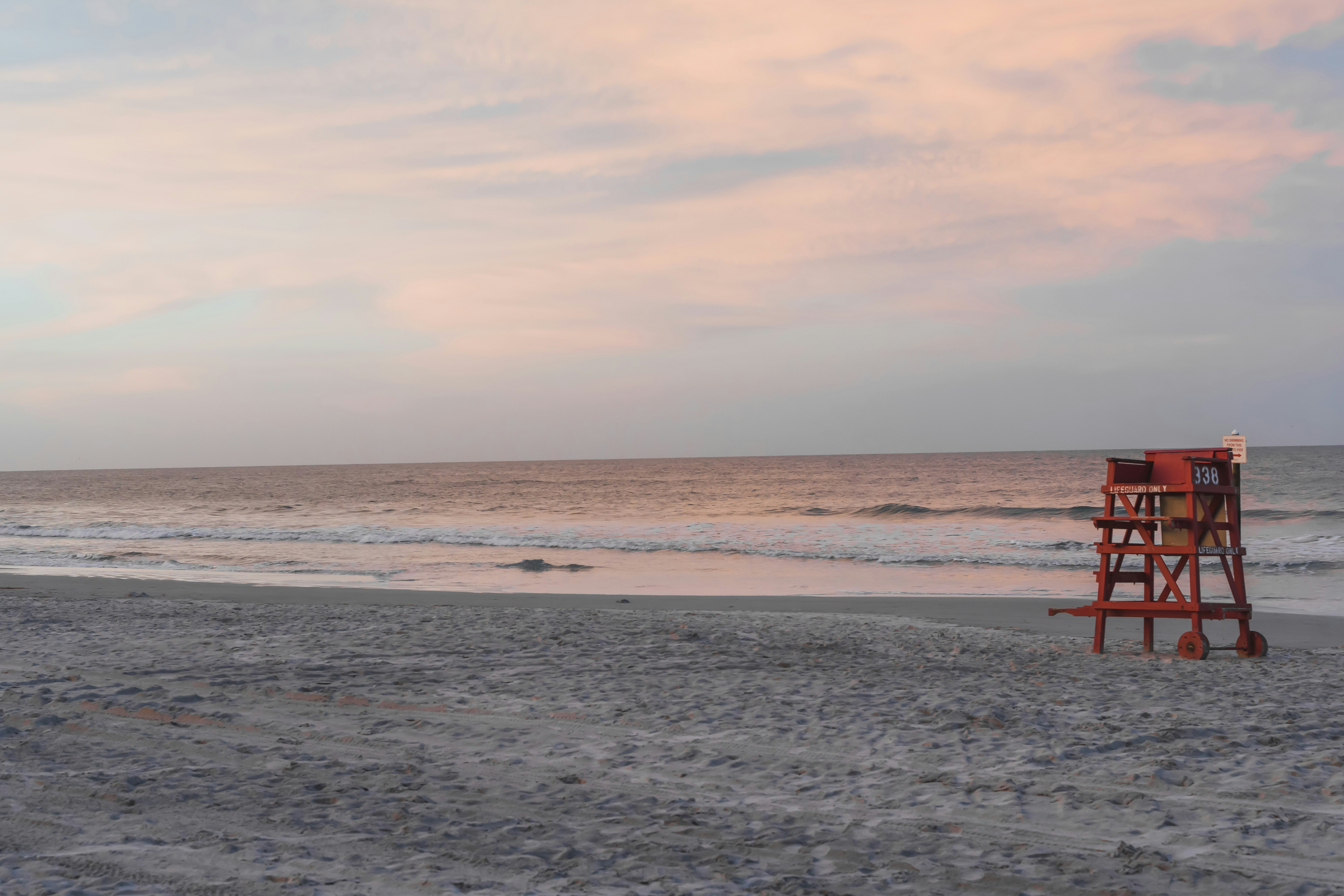 Sunset over the beach near Ormond Beach and Daytona Beach, Florida, with a lifeguard chair on the empty sand